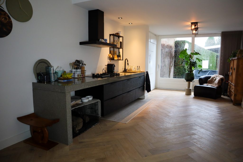 Moderne keuken met zwart aanrecht en houten vloer