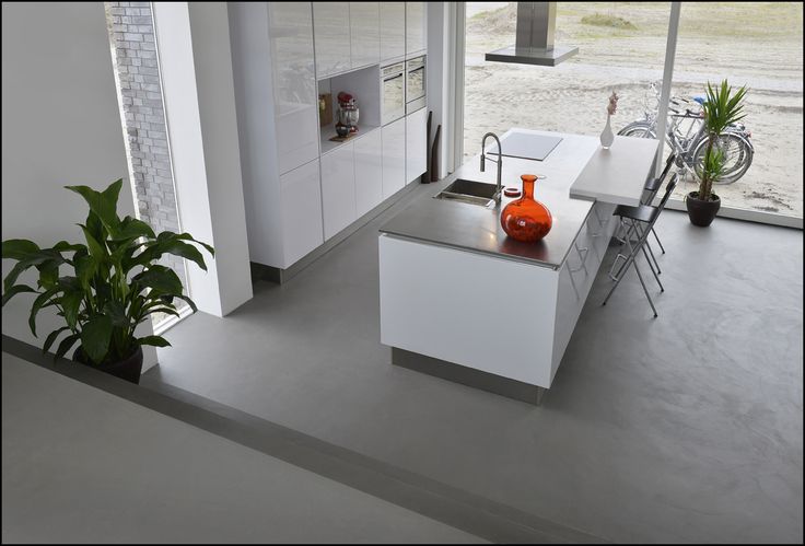 Moderne keuken met planten en glazen deur.