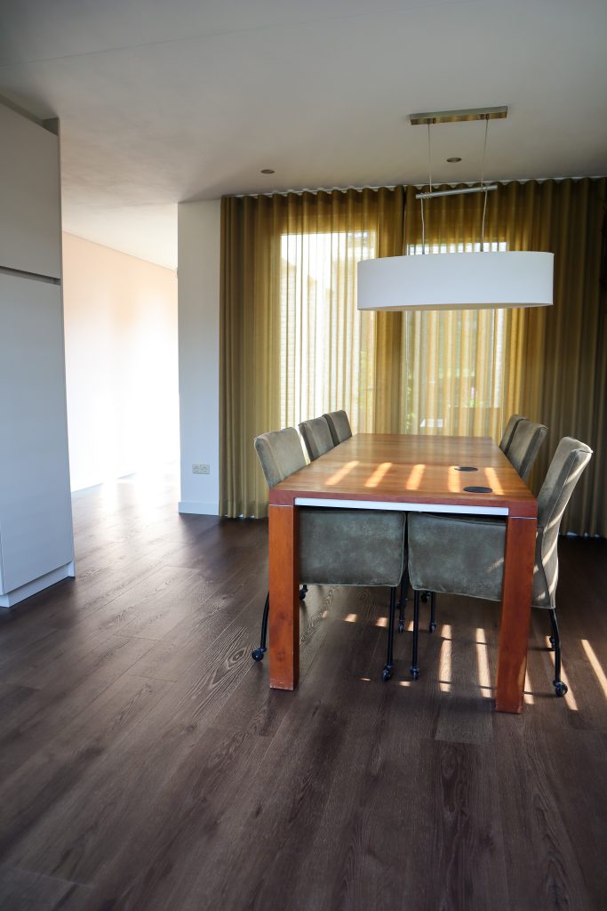 Eetkamer met houten tafel en stoelen.