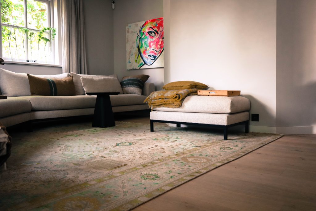 Moderne woonkamer met kunst, bank en vloerkleed.