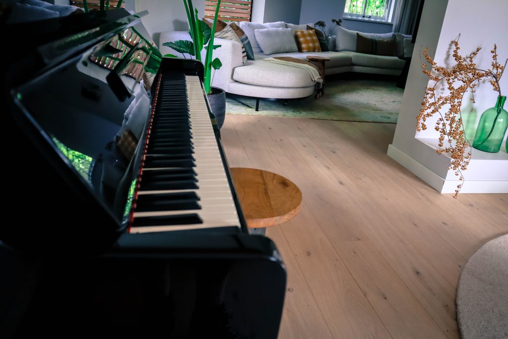 Piano in stijlvolle woonkamer met grote bank.
