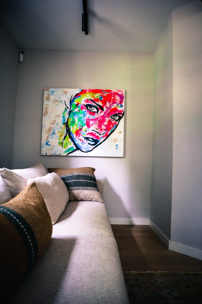 Abstract schilderij boven beige bank in woonkamer.